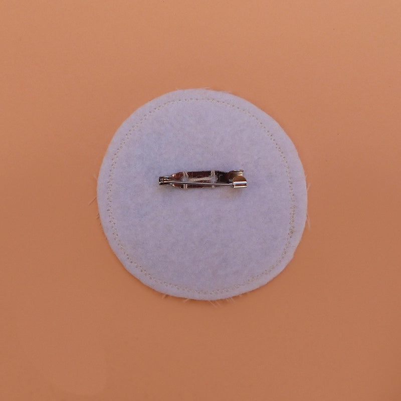 Broche fabriquée à la main avec des chutes de tissus. Feutrine lavable à l'arrière.