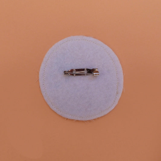 Broche fabriquée à la main avec des chutes de tissus. Feutrine lavable à l'arrière.