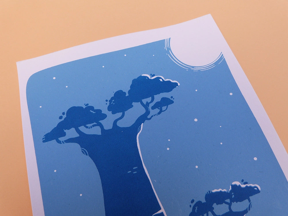 Impression d'une carte en sérigraphie artisanale. Illustration faite à la main représentant l'Allée des Baobabs à Madagascar, de nuit, avec un lémurien caché dans les branches.