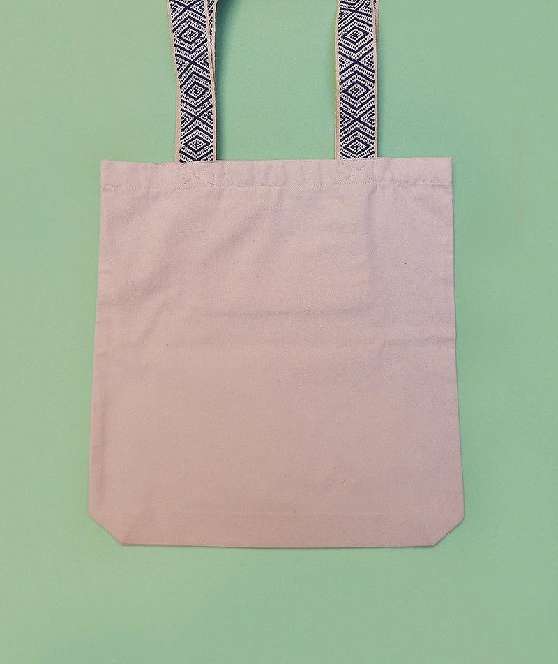 Grand totebag fabriqué en matières recyclées. Poche zippée à l'intérieur. Anses larges et confortables. Impression française. Illustration d'un chat regardant les toits de Paris la nuit.
