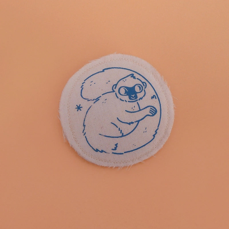 Broche mignonne fabriquée à la main avec des chutes de tissus. Dessin de lémurien à front blanc.