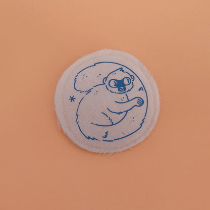 Broche mignonne fabriquée à la main avec des chutes de tissus. Dessin de lémurien à front blanc.