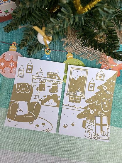 Carte de vœux sérigraphiée artisanalement. Décor cosy de fêtes. Cheminée, biscuits, chocolat chaud, sapin et cadeaux.