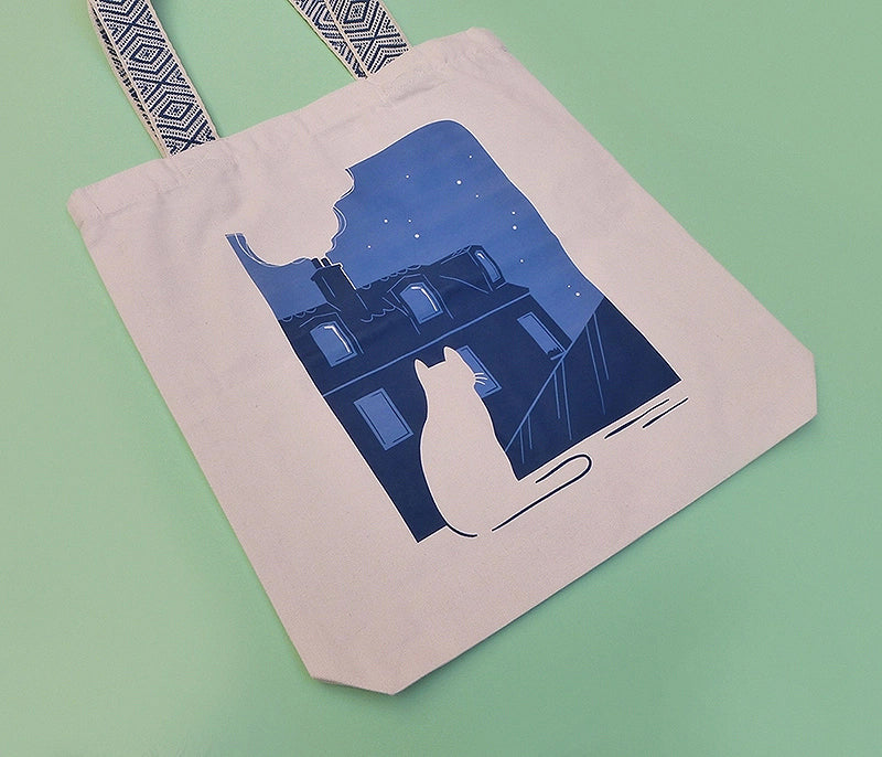 Grand totebag fabriqué en matières recyclées. Impression française. Illustration d'un chat regardant les toits de Paris la nuit.
